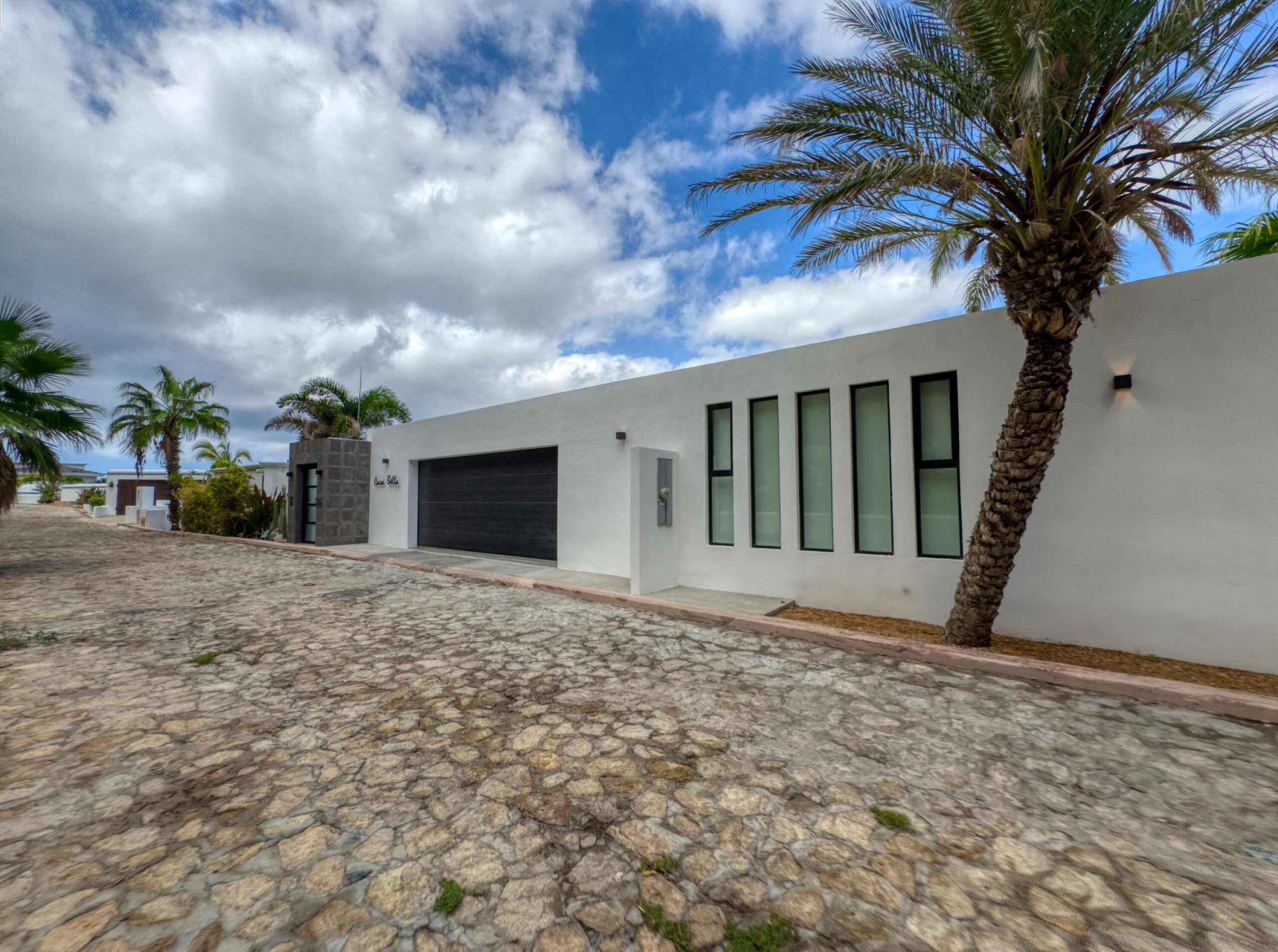 Los Cabos Luxury Las Tunas The Nacuii Residence is a refined luxury home crafted to exceed the expectations of even the most discerning buyer. Nestled on a generous and private 3,000 m² lot (0.73 acres), it's just a short, effortless stroll to the untouched, sandy shores of Las Tunas — perfect for enjoying the serene coastal landscape and dramatic sunsets. The home offers a thoughtful layout with 3 spacious bedrooms, a separate studio, a cozy TV lounge, and 6 full bathrooms, including two principal suites, a guest room, a detached studio, and a dedicated media or family room. Expansive sliding glass doors invite natural light throughout the interiors while showcasing tranquil garden for sale